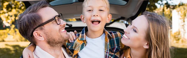 Cheerful Son Embracing Parents Car Blurred Background Outdoors Banner — Stock Photo, Image