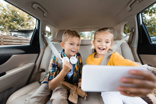 Smiling Kids Toys Headphones Taking Selfie Smartphone Blurred Foreground Car — Stock Photo, Image