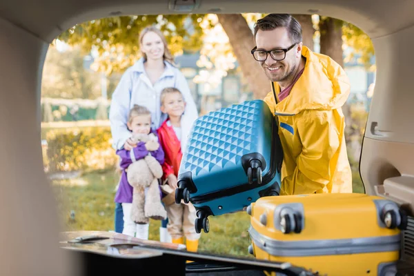 Smiling Man Autumn Outfit Holding Suitcase Trunk Car Family Blurred — Stock Photo, Image