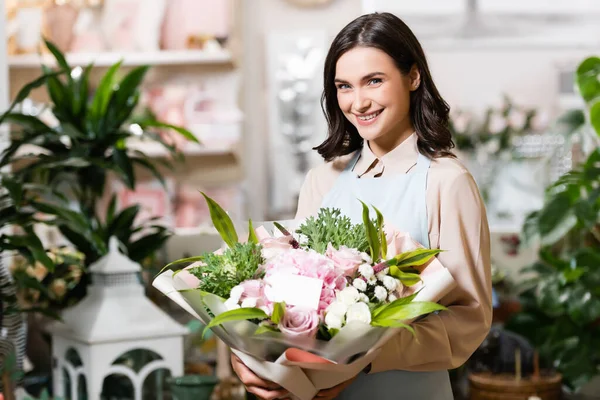 Giovane Fiorista Sorridente Alla Fotocamera Mentre Tiene Bouquet Con Tag — Foto Stock