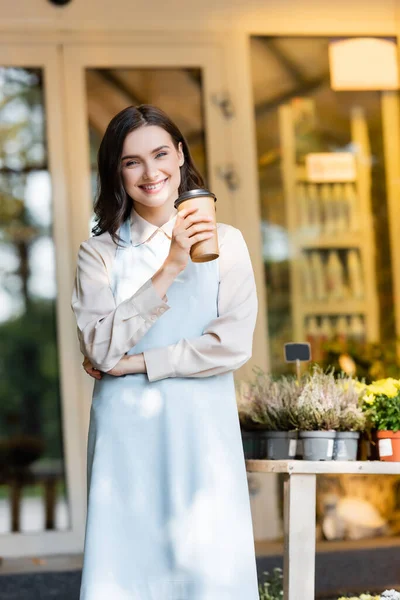 Smiling Florist Holding Coffee Flower Shop Potted Plants Blurred Background — Stock Photo, Image