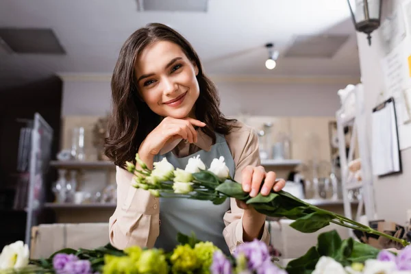 Glad Florist Tittar Kameran Medan Håller Eustoma Blommor Suddig Förgrund — Stockfoto