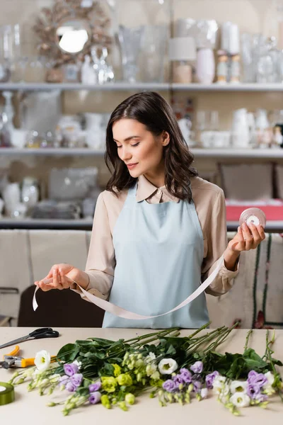 Florist Apron Holding Decorative Ribbon Eustoma Flowers Table Rack Vases — Stock Photo, Image