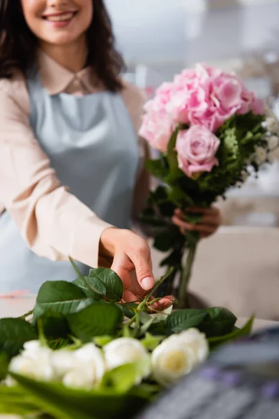 背景にブーケを構成しながら デスクから立ち上がる女性花屋の作物のビュー — ストック写真