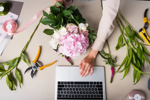 Vista Recortada Floristería Femenina Usando Computadora Portátil Mientras Sostiene Ramo — Foto de Stock