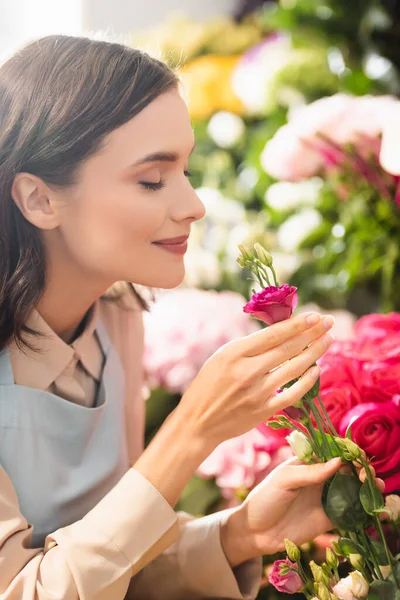 Brunette Florist Closed Eyes Smelling Eustoma Flower Roses Blurred Background — Stock Photo, Image
