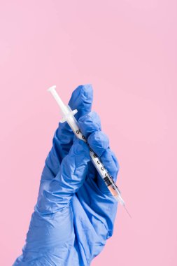 cropped view of hand in latex glove with syringe isolated on pink clipart