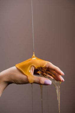 Gri üzerine izole edilmiş ballı kadın eli görüntüsü