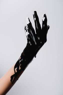 Kırpılmış el görüntüsü ve damlayan siyah boya beyaza izole edilmiş.