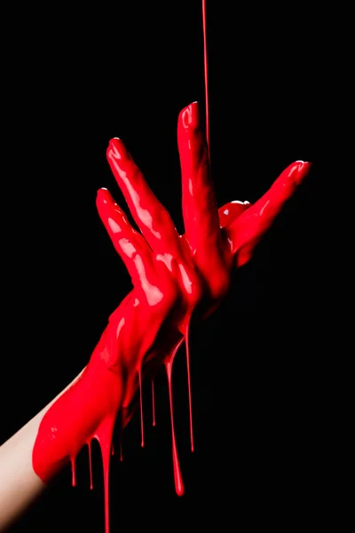 黒の上に赤の滴下塗料で描かれた手の部分的なビュー — ストック写真