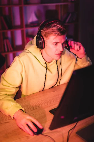 Young Man Using Headset While Gaming Computer Blurred Foreground — Stock Photo, Image