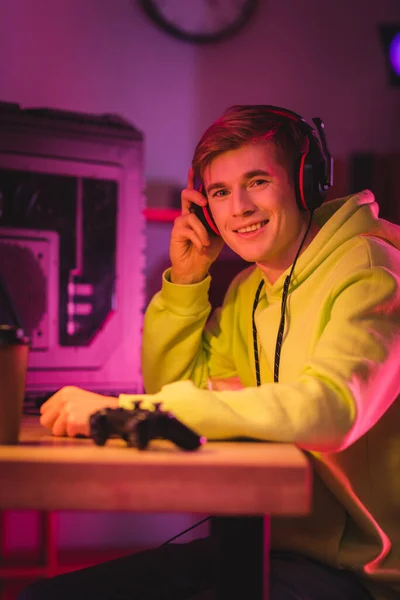 Sorrindo Gamer Segurando Fones Ouvido Perto Joystick Café Para Primeiro — Fotografia de Stock