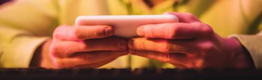 Akıllı telefon ve afişte oyun oynayan oyuncunun kırpılmış görünümü 