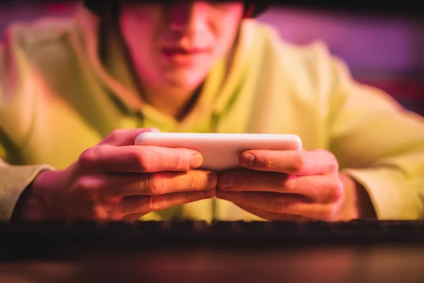 Smartphone Nelle Mani Del Giocatore Vicino Alla Tastiera Del Computer — Foto Stock