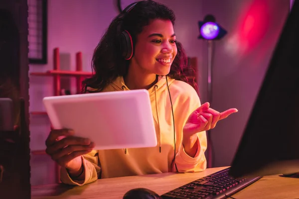 Sonriente Jugador Afroamericano Auriculares Apuntando Con Dedo Computadora Mientras Sostiene — Foto de Stock