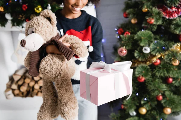 Vista Recortada Sonriente Niña Afroamericana Sosteniendo Caja Regalo Oso Peluche — Foto de Stock