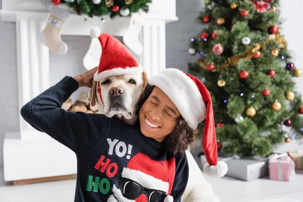 Excited African American Girl Closed Eyes Hugging Labrador Dog Christmas — Stock Photo, Image
