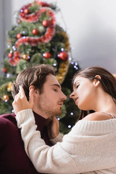 Zijaanzicht Van Gepassioneerd Paar Omarmen Buurt Versierde Kerstboom Wazig Achtergrond — Stockfoto