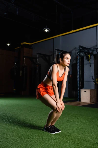 Jovem Esportista Shorts Sutiã Esportivo Olhando Para Longe Enquanto Aquece — Fotografia de Stock