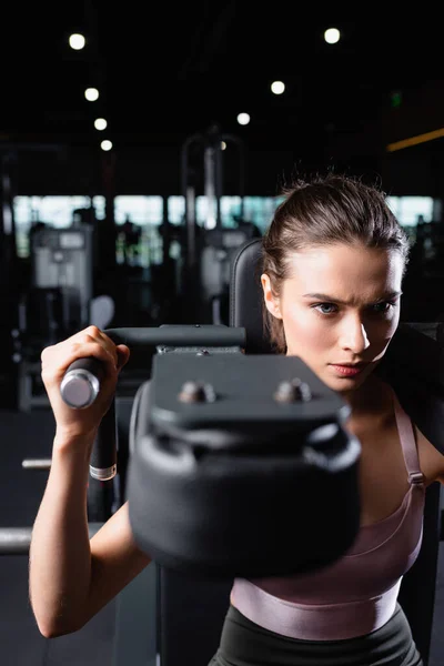 Spor Yapan Bir Kadın Bulanık Planda Eğitim Makinesinde Silah Geliştirme — Stok fotoğraf