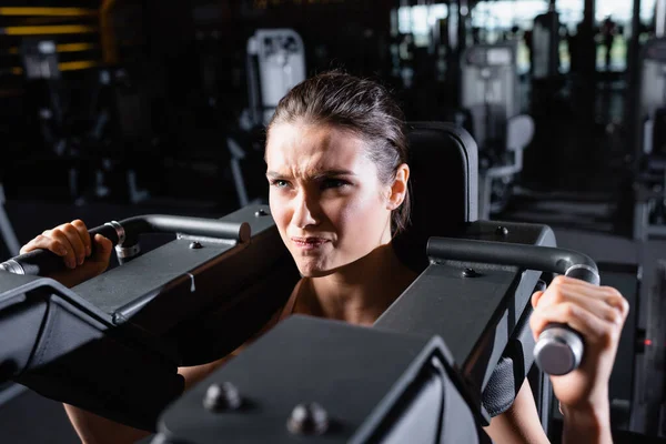 Gespannen Sportvrouw Uit Werken Armen Uitbreiding Machine Sportschool — Stockfoto