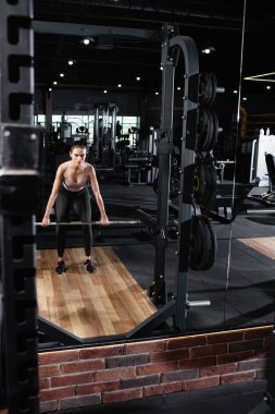 Spor merkezinde güç rafı olan atletik kadın antrenmanı 