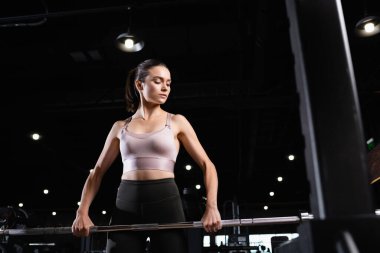 Spor salonunda spor sutyen eğitimi alan atletik bir kadın.