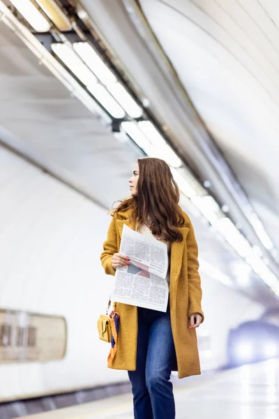 Junge Frau Mantel Hält Zeitung Der Hand Während Sie Bahnsteig — Stockfoto