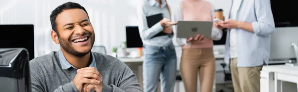 Cheerful Indian Businessman Sitting Computer Colleagues Blurred Background Office Banner — Stock Photo, Image