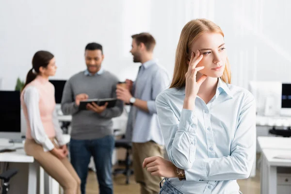 Pensive Zakenvrouw Staan Buurt Van Collega Die Werken Wazig Achtergrond — Stockfoto