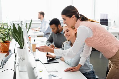 Ofiste grafik tableti ve bilgisayar kullanan gülümseyen iş kadınları 