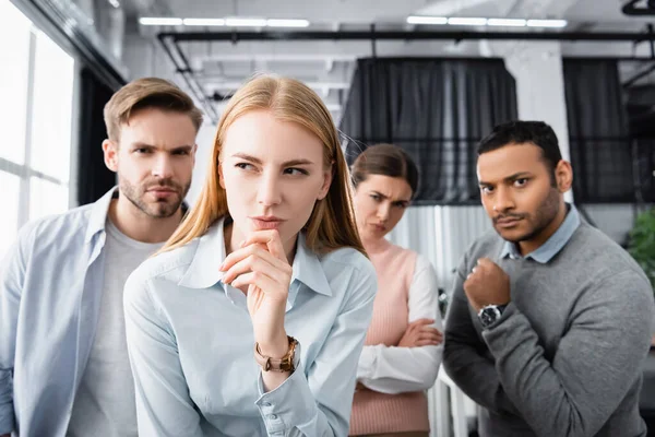 多民族の同僚の近くに立っている高価なビジネス女性がオフィスでぼやけた背景に — ストック写真