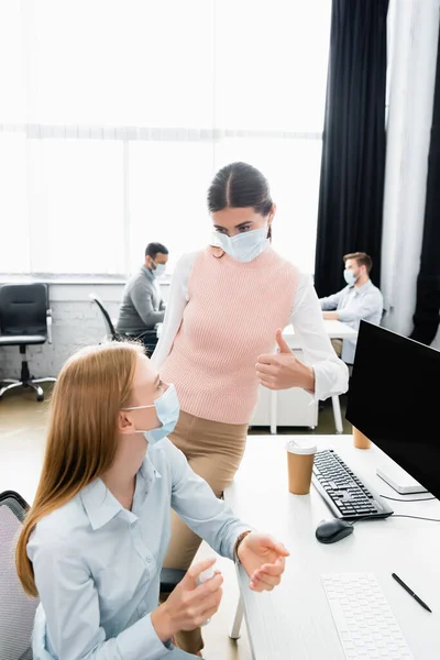 Businesswoman Medical Mask Showing Colleague Using Hand Sanitizer Office — Stock Photo, Image