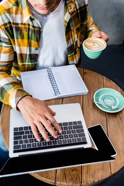 Partiell Bild Frilansare Skriva Laptop Och Hålla Kopp Kaffe Med — Stockfoto