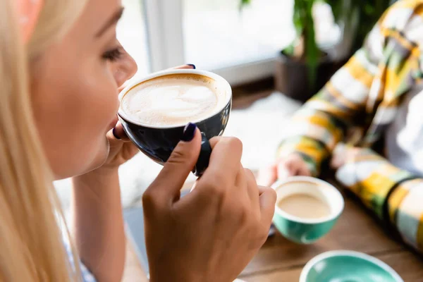 Cropped View Woman Drinking Coffee Man Blurred Background Cafe — Stock Photo, Image