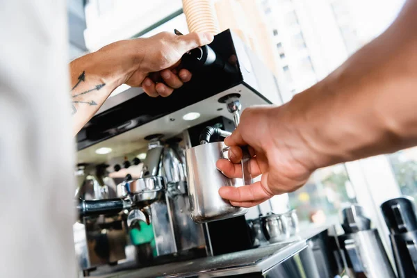 Částečný Pohled Baristu Držícího Kovový Hrnek Mlékem Blízkosti Kávovaru Rozmazaném — Stock fotografie