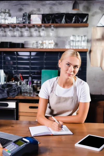 Jeune Blonde Barista Écriture Dans Portable Près Tablette Numérique Terminal — Photo