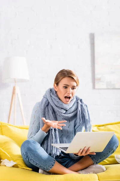 Wanita Yang Gembira Dan Sakit Melihat Laptop Dekat Serbet Sofa — Stok Foto