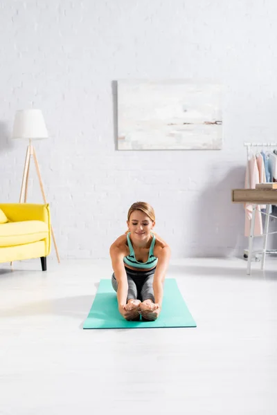 Lächelnde Sportlerin Dehnt Sich Bei Yoga Übungen Auf Fitnessmatte — Stockfoto