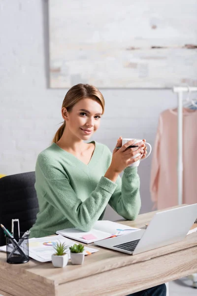 Freelancer Sorridente Segurando Caneta Xícara Perto Documentos Notebook Laptop Primeiro — Fotografia de Stock