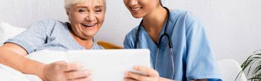cheerful nurse and happy elderly woman using digital tablet together, banner clipart