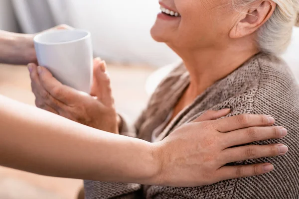 Recortado Vista Enfermera Tocando Hombro Sonriente Anciana Dando Escuchar Taza —  Fotos de Stock