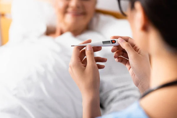 Cropped View Nurse Holding Thermometer Aged Patient Blurred Background — Stock Photo, Image