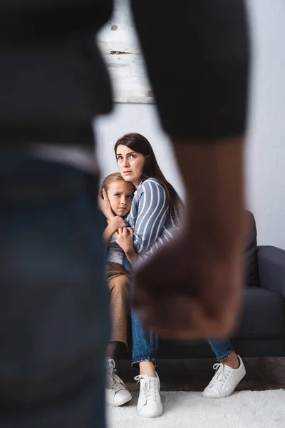 Frightened Woman Hugging Child Abusive Husband Blurred Foreground Home — Stock Photo, Image