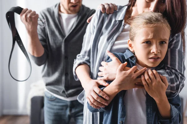 Scared Child Embracing Mother Angry Father Holding Waist Belt Blurred — Stock Photo, Image