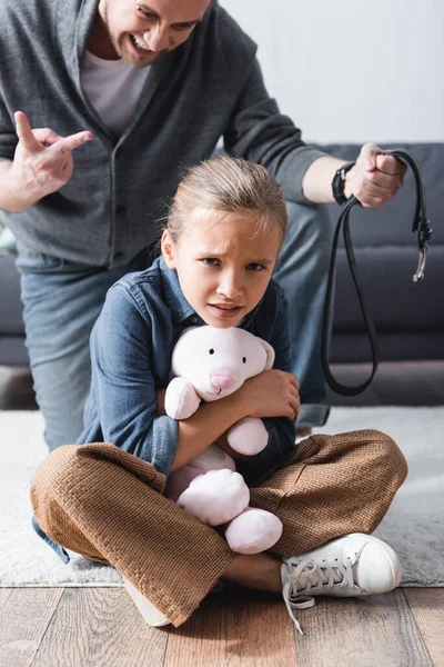 Scared Child Holding Soft Toy Angry Father Waist Belt Blurred — Stock Photo, Image