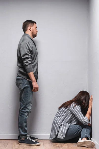 Hombre Abusivo Mirando Esposa Con Moretones Mano Sentado Suelo Cerca — Foto de Stock