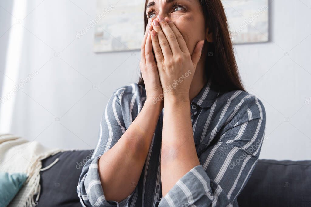 Depressed woman with bruises crying at home 