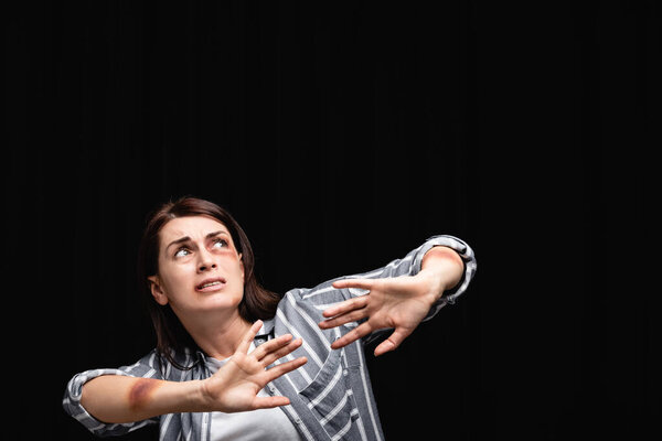 Испуганная жертва домашнего насилия, не показывающая жеста, изолированного от черного 