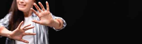 Cropped view of scared woman with bruises on hands showing no gesture isolated on black, banner 